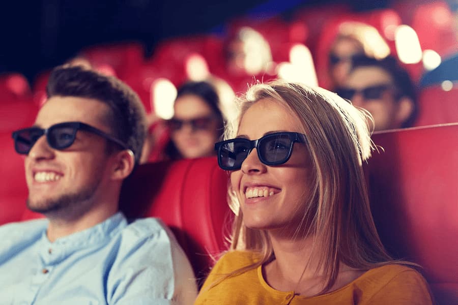 2 personnes avec des lunettes 3D au cinéma